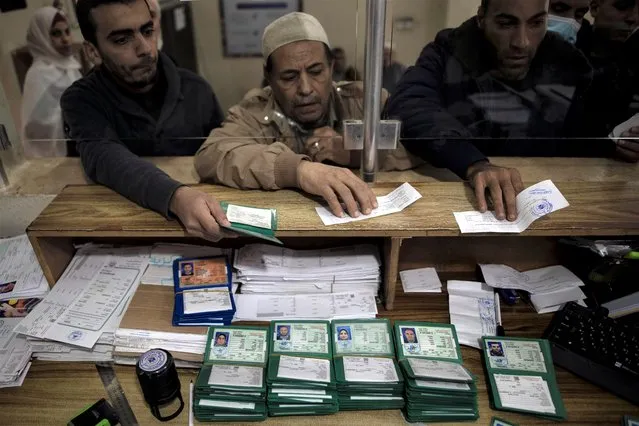Palestinians wait to receive their national IDs at the civil affairs office in Gaza City, Wednesday, January 5, 2022. In recent months, Israel has approved residency for thousands of Palestinians in the occupied West Bank and Gaza, allowing them to get an official Palestinian ID number that grants them the possibility to travel abroad and clear up years of uncertain legal status. (Photo by Khalil Hamra/AP Photo)