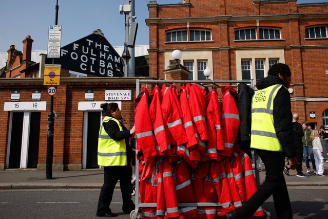 Stewards push racks of hi-vis jackets outside Craven Cottage stadium ahead of the English Premier League soccer match between Fulham and Manchester City in London, Britain, 11 May 2024. (Photo by David Cliff/EPA)