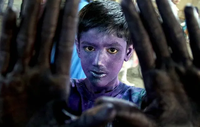 A Hindu boy with his face covered in colors celebrates the festival of Holi in Karachi, Pakistan, 12 March 2017. “Holi” is an ancient Hindu festival symbolizing the victory of good over evil as well as the arrival of spring. Revellers celebrate Holi by covering each other in colored powders. (Photo by Shahzaib Akber/EPA)