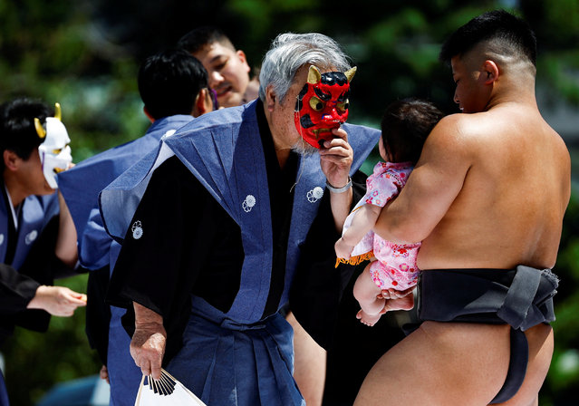 Ring assistants wear masks to scare babies held up by amateur sumo wrestlers during “Nakizumo” or a baby-crying sumo contest at Sensoji temple in Tokyo, Japan, on April 28, 2024. (Photo by Issei Kato/Reuters)