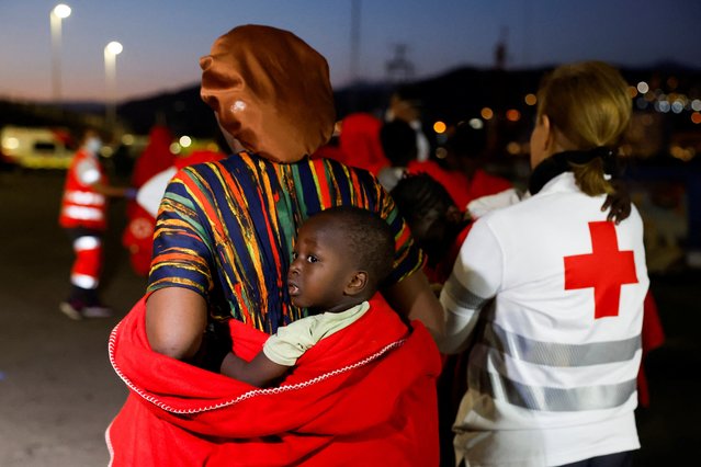 Migrants walk towards a Red Cross tent after disembarking from a Spanish coast guard vessel, in the port of Arguineguin, on the island of Gran Canaria, Spain, on May 13, 2024. (Photo by Borja Suarez/Reuters)