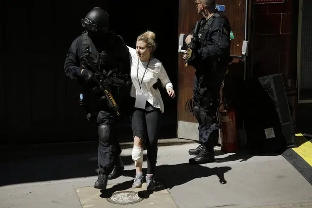 During a training exercise for London's emergency services, a casualty is helped by an armed police officer, outside the disused Aldwych underground train station in London, Tuesday, June 30, 2015. (Photo by Matt Dunham/AP Photo)