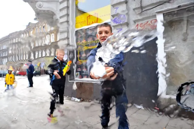 Young people sprinkle water from buckets on each other on Easter Monday in Szczecin, Poland, 21 April 2014. Watering on Easter Monday is a tradition in Poland. (Photo by Marcin Bielecki/EPA)