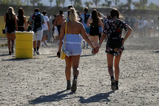 Girls walk hand in hand though a parking lot toward the Coachella Valley Music and Arts Festival in Indio, California, U.S. April 15, 2017. (Photo by Carlo Allegri/Reuters)
