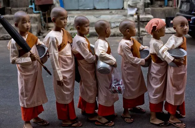 Novice Buddhist nuns stand in front of a house to collect alms in Yangon, Myanmar, Thursday, May 12, 2016. Close to 90 percent of Myanmar's population are believed to be Theravada Buddhists. (Photo by Gemunu Amarasinghe/AP Photo)