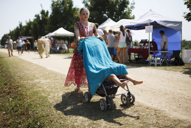 A worshipper of Lord Krishna pushes a pram during the annual Krishna Valley Festival in Somogyvamos, some 190 kms south of Budapest, Hungary, 19 July 2015. (Photo by Gyorgy Varga/EPA)
