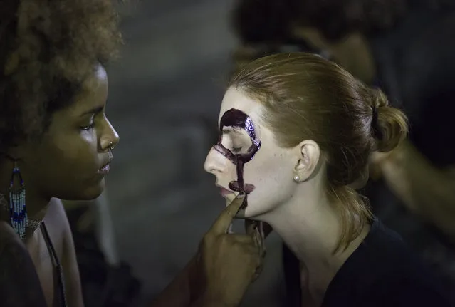 Women paint their faces with female gender symbols for a protest against the gang rape of a 16-year-old girl in Rio de Janeiro, Brazil, Friday, May 27, 2016. The assault last Saturday came to light after several men joked about the attack online, posting graphic photos and videos of the unconscious, naked teen on Twitter. (Photo by Leo Correa/AP Photo)