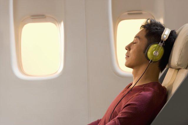 Man resting and listening to music on airplane. (Photo by Gareth Brown/Getty Images)