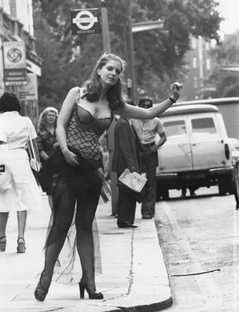 1975: Jane Keiren, a Public Relations executive from London auction house Christie's of Kensington, wearing a dress worn by Marilyn Monroe in the film, 'Bus Stop' whilst standing by a Bus Stop on Brompton Road, London