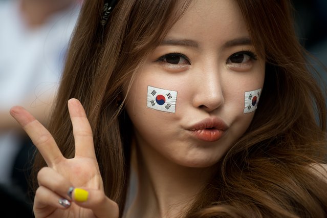 A South Korean football fan poses during a public screening in Seoul of the South Korea vs Russia football match at the 2014 World Cup in Brazil, early on June 18, 2014. Giant television screens were erected around Seoul ahead of the country's first game at the 2014 Brazilian World Cup. South Korea drew with Russia leaving both countries trailing Belgium who head the Group H table after beating Algeria 2-1 earlier. (Photo by Ed Jones/AFP Photo)