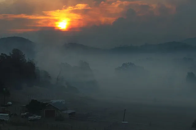 The sun rises over an area smothered with smoke from the Rocky Fire on July 31, 2015 in Lower Lake, California. Over 900 firefighters are battling the Rocky Fire that erupted to over 15,000 acres since it started on Wednesday afternoon. The fire is currently five percent contained and has destroyed 3 homes. (Photo by Justin Sullivan/Getty Images)