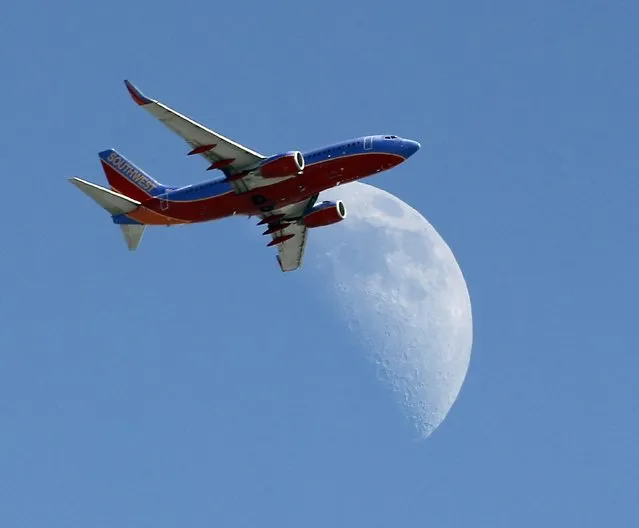 In this September 1, 2014 file photo, a Southwest Air flight   crosses over a crescent moon as it passes over Whittier, Calif. Southwest Air reports earnings later Thursday April 23, 2015. (Photo by Nick Ut/AP Photo)