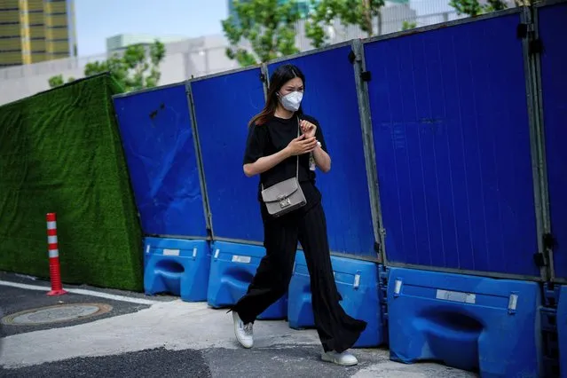 A woman wearing a protective face mask walks on a street, after the lockdown placed to curb the coronavirus disease (COVID-19) outbreak was lifted in Shanghai, China on June 8, 2022. (Photo by Aly Song/Reuters)