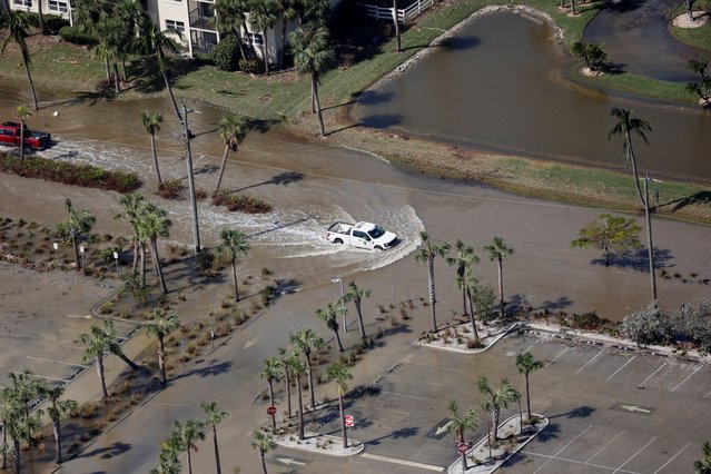 An aerial view shows a car driving through a flooded street after Hurricane Milton's landfall, in Siesta Key, Florida, on October 10, 2024. (Photo by Marco Bello/Reuters)