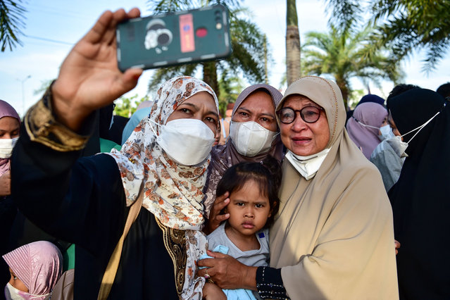 People pose for a group photo before sending off their relatives, heading to Mecca in Saudi Arabia for the annual Hajj pilgrimage, from the Narathiwat provincial airport in southern Thailand on June 10, 2022. (Photo by Madaree Tohlala/AFP Photo)