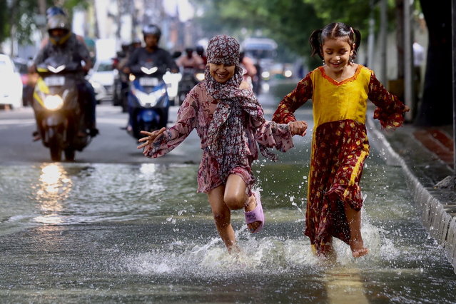 Childrens play in the waterlogged streets following heavy rain in Bangalore, India, 21 October 2024. India Meteorological Department (IMD), weather department issued an orange alert amid intermittent rain. Due to heavy rains in Bangalore, schools are shut down today, and private offices have asked their employees to work from home, and several trees are uprooted. This comes owing to a well-marked low-pressure area over central parts of the south Bay of Bengal. (Photo by Jagadeesh N.V./EPA)