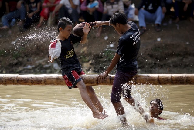 Boys play a pillow-fighting game called “gebuk kasur” during celebrations for Indonesia's 70th Independence Day along Kalimalang river in Jakarta, Indonesia, August 17, 2015. (Photo by Nyimas Laula/Reuters)