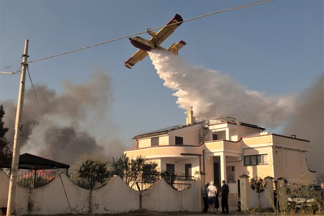 A Canadair aircraft attempts to extinguish a wildfire in Posada in the province of Nuoro on August 06, 2023 in Posada, Italy. A number of homes and resorts in the area have been evacuated as strong mistral winds help fuel the flames, being tackled by firefighting and civil protection teams along with helicopters and Canadair aircraft. (Photo by Emanuele Perrone/Getty Images)