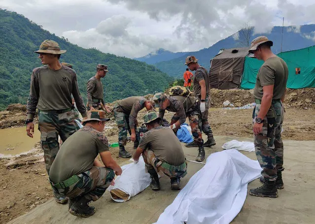 Soldiers wrap bodies of victims of a mudslide in Noney, northeastern Manipur state, India, Friday, July 1, 2022. Rescuers found more bodies Friday as they resumed searching for dozens of missing after a mudslide triggered by weeks of heavy downpours killed at least 19 people at a railroad construction site in India's northeast, officials said. (Photo by Agui Kamei/AP Photo)