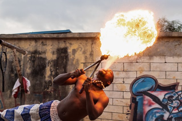 A fire breather performs during a slum party in Oworonshoki district of Lagos, Nigeria, 24 September, 2024. The slum party is a yearly artistic dance festival initiated by Ennovate Dance House. It highlights the positive sides of the slum community and brings hope to the inhabitants. (Photo by Emmanuel Adegboye/EPA/EFE)