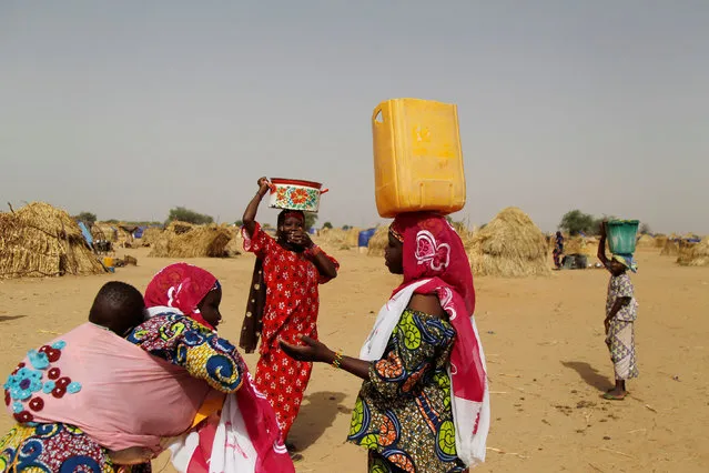 Women carry water at the Boudouri site for displaced persons outside the town of Diffa in southeastern Niger June 18, 2016. (Photo by Luc Gnago/Reuters)