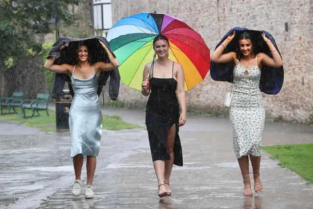 The Heavens opened as students from Wells Blue school year 13 pupils arrived at The Bishop's Palace in Wells, Somerset on June 30, 2022 for their end of year school prom. (Photo by Jason Bryant/Apex News)