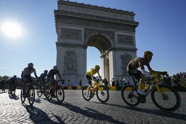 Denmark's Jonas Vingegaard, wearing the overall leader's yellow jersey, passes Arc de Triomphe during the twenty-first stage of the Tour de France cycling race over 116 kilometers (72 miles) with start in Paris la Defense Arena and finish on the Champs Elysees in Paris, France, Sunday, July 24, 2022. (Photo by Thibault Camus/AP Photo)