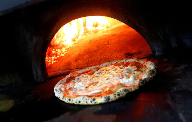 Pizza Margherita is prepared in a wood-fired oven at L'Antica Pizzeria da Michele in Naples, Italy on December 6, 2017. (Photo by Ciro De Luca/Reuters)