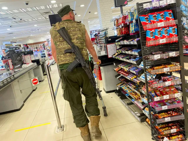 A Ukrainian serviceman pushes a trolley inside a supermarket, as Russia's invasion of Ukraine continues, in Kharkiv, Ukraine on August 7, 2022. (Photo by Nacho Doce/Reuters)
