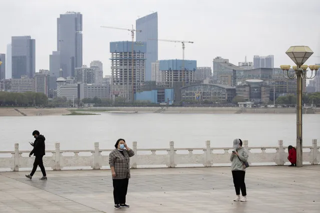 Residents observe social distancing at a park along the Yangtze River in Wuhan in central China's Wuhan province on Wednesday, April 1, 2020. Skepticism about China’s reported coronavirus cases and deaths has swirled throughout the crisis, fueled by official efforts to quash bad news in the early days and a general distrust of the government. In any country, getting a complete picture of the infections amid the fog of war is virtually impossible. (Photo by Ng Han Guan/AP Photo)