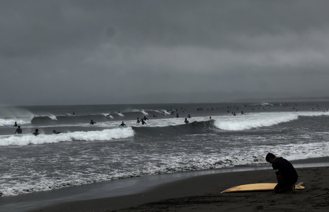People enjoy surfing in Fujisawa, near Tokyo, Sunday, September 17, 2017. A strong typhoon made landfall on the Japanese island of Kyushu on Sunday morning as heavy rain has fallen and the wind is also strengthened in the area. (Photo by Shizuo Kambayashi/AP Photo)