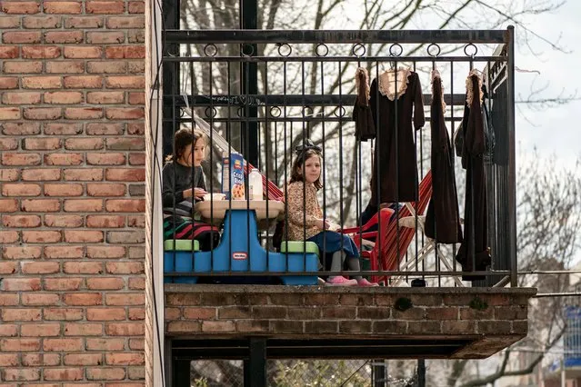 Children have a meal at the balcony during the outbreak of the coronavirus disease (COVID-19) in New York City, U.S., April 5, 2020. (Photo by Jeenah Moon/Reuters)