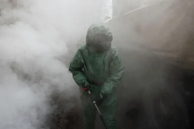 A Russian army serviceman wearing protective gear sprays disinfectant while sanitizing a factory amid the coronavirus disease (COVID-19) outbreak in Saint Petersburg, Russia oon April 15, 2020. (Photo by Anton Vaganov/Reuters)