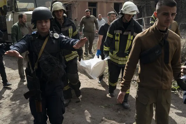 Firefighters carry a bag containing a body of a person after a Russian attack that heavily damaged a residential building in Sloviansk, Ukraine, Wednesday, September 7, 2022. (Photo by Leo Correa/AP Photo)