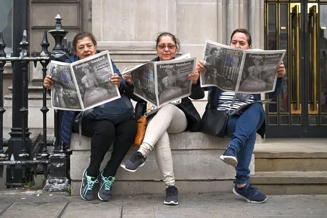 Three Guatemalan tourists read London's main free newspaper The Evening Standard in central London, on September 9, 2022, a day after Queen Elizabeth II died at the age of 96. Queen Elizabeth II, the longest-serving monarch in British history and an icon instantly recognisable to billions of people around the world, died at her Scottish Highland retreat on September 8. (Photo by Justin Tallis/AFP Photo)