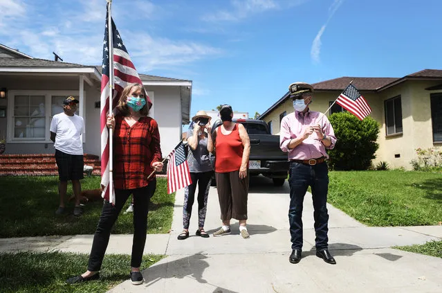 People gather for the drive-by birthday party for World War II veteran Lt. Colonel Sam Sachs, who turned 105 today, amid the coronavirus pandemic on April 26, 2020 in Lakewood, California . His planned birthday celebration inside his retirement home was cancelled due to the spread of COVID-19 but members of the community turned out on foot and in vehicles outside the home to help him celebrate.  He also received thousands of cards from well wishers across the country. (Photo by Mario Tama/Getty Images)