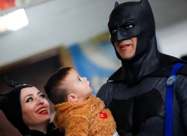 Argentine volunteer and organizer of the so-called Hero Club (Club de Heroes), Damian Gomez, who impersonates comic book superhero Batman, plays with the son of an inmate during a visit at the 33rd prison in Los Hornos as part of a wider program for vulnerable minors, on the outskirts of Buenos Aires, Argentina on April 30, 2022. (Photo by Agustin Marcarian/Reuters)