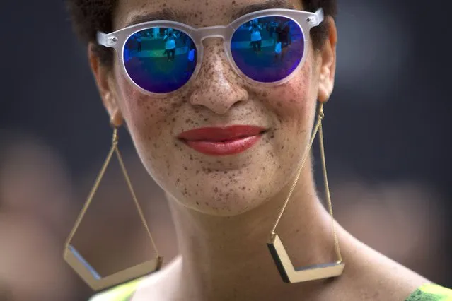 A fashionista wearing sunglasses smiles as she walks around Lincoln Center during New York Fashion Week in the Manhattan borough of New York September 6, 2014. (Photo by Carlo Allegri/Reuters)