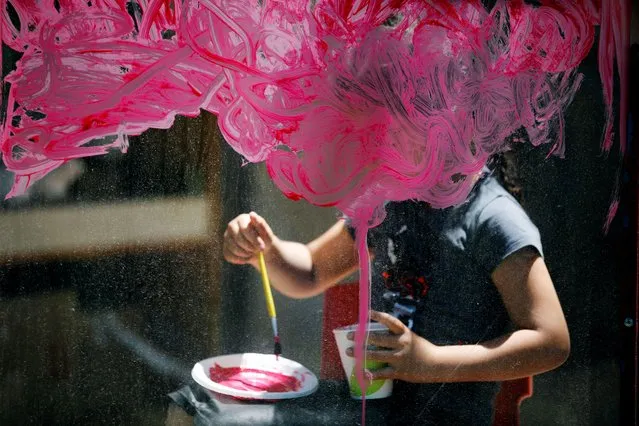 A girl paints on glass at her kindergarten as preschools across Israel opened under the further easing of restrictions to prevent the coronavirus disease (COVID-19) spread, in Jerusalem on May 10, 2020. (Photo by Amir Cohen/Reuters)