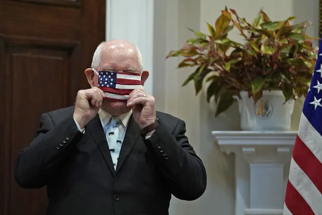 Agriculture Secretary Sonny Perdue adjusts his mask before an event in the Roosevelt Room of the White House, Tuesday, May 19, 2020, in Washington. (Photo by Evan Vucci/AP Photo)