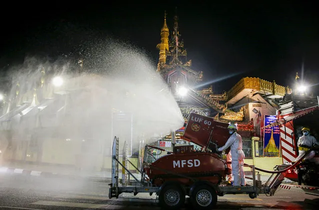 Firefighters wearing PPE (Personal protective equipment) spray disinfectant to curb the spread of coronavirus, near Sule pagoda at downtown area in Yangon, Myanmar, 24 April 2020. Countries around the world are taking increased measures to stem the widespread of the SARS-CoV-2 coronavirus which causes the Covid-19 disease. (Photo by Lynn Bo Bo/EPA/EFE/Rex Features/Shutterstock)