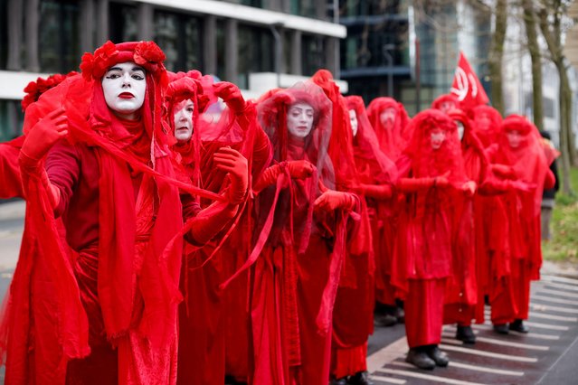 Members of Extinction Rebellion Red Rebel Brigade take part in a climate protest coinciding with COP28 being held in Dubai and ahead of the upcoming Belgian presidency of the Council of the European Union, in Brussels, Belgium on December 3, 2023. (Photo by Johanna Geron/Reuters)