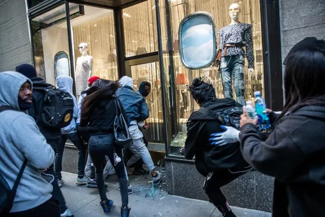 People take luxury products from a smashed storefront during a protest against the death in Minneapolis police custody of George Floyd, in the Manhattan borough of New York City, U.S., June 1, 2020. (Photo by Jeenah Moon/Reuters)