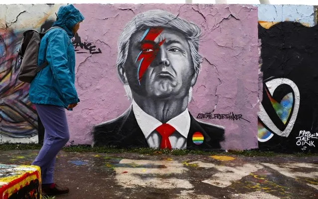 A man walks by a mural depicting of the U.S. President Donald Trump by Dominican graffiti artist Jesus Cruz also known with his nickname as EME Freethinker is seen in Mauerpark in Berlin, Germany on May 11, 2020. Coronavirus graffitis of EME Freethinker became popular after his depicting of “Gollum” from Lord Of The Rings with a message reading “my precious” to refer the crisis of hoarding toilet papers throughout Europe amid the novel coronavirus (COVID-19) pandemic. U.S. President Donald Trump, President of the People's Republic of China Xi Jinping and Bob Marley also among this popular graffiti. (Photo by Abdulhamid Hosbas/Anadolu Agency via Getty Images)