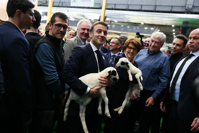 France's President Emmanuel Macron holds a lamb during the opening day and inauguration by France's President of the 61st International Agricultural Fair (Salon de l'Agriculture) at the Porte de Versailles exhibition centre in Paris, on February 22, 2025. The 2025 edition of the SIA (Salon International de l'Agriculture) Agriculture is held in Paris from February 22, to March 2, 2025. (Photo by Alain Jocard/Pool via AFP Photo)