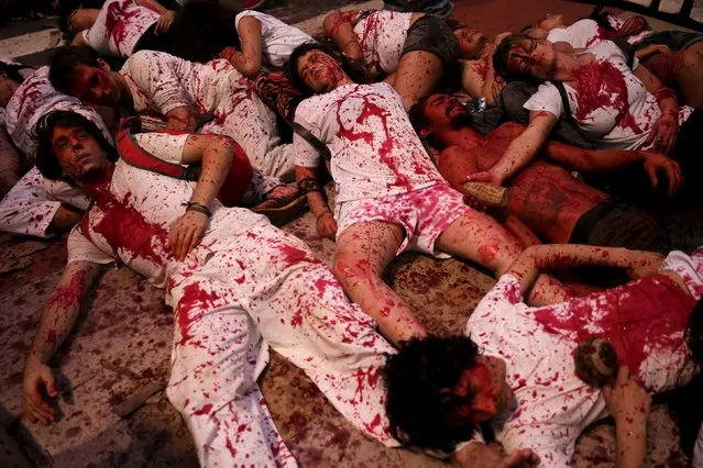 Activists covered in fake blood perform during a protest against the death of Semiao Vilhalva, a leader of the Guarani Kaiowa tribe, in Sao Paulo September 17, 2015. The organisers of the protest said Vilhalva was shot dead on August 29 during a confrontation with men trying to expel tribe members from land the tribe had earlier occupied in the municipality of Antonio Joao, Mato Grosso do Sul state. Police are investigating the case. (Photo by Nacho Doce/Reuters)