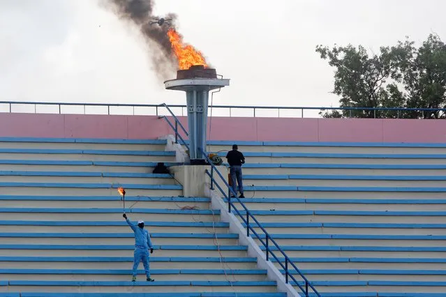 A ceremonial torch is lit to mark the reopening of the stadium in Mogadishu, Somalia Tuesday, June 30, 2020. At least three mortar blasts struck the Mogadishu Stadium Tuesday evening, just hours after it was reopened by Somalia's President Mohamed Abdullahi Mohamed, who had left before the shells hit, following years of instability. (Photo by Farah Abdi Warsameh/AP Photo)