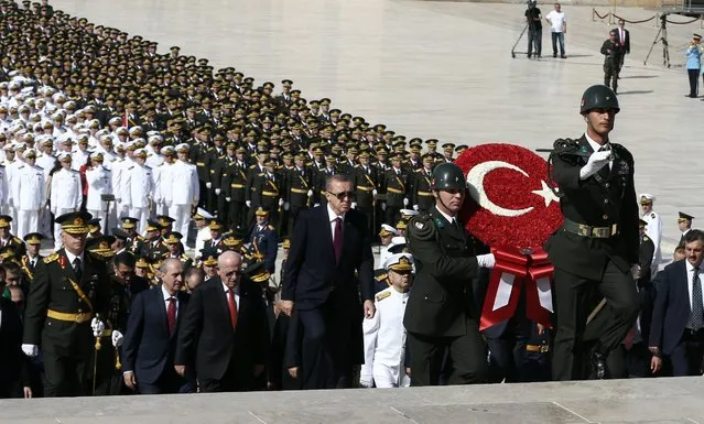 Turkish President Recep Tayyip Erdogan, center, ministers and army commanders follow a guard of honor at the mausoleum of modern Turkey's founder Mustafa Kemal Ataturk on Victory Day in Ankara, Turkey, Tuesday, August 30, 2016. Turkish army's 94-year-old victory over Greece was considered crucial in Turkish Independence War and the foundation of modern Turkish republic. (Photo by Burhan Ozbilici/AP Photo)