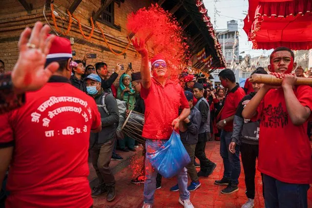 A man hurls vermillion colors in the air to celebrate the Sindoor Jatra festival at Chabahil, in Kathmandu on November 11, 2022. During this festival, devotees smear vermillion colors onto each other's faces in the belief to rid one of skin diseases. On this day devotees pray to Lord Ganesh and Bhairav and draw a large number of people from around the city every year. (Photo by Skanda Gautam/SOPA Images/Rex Features/Shutterstock)