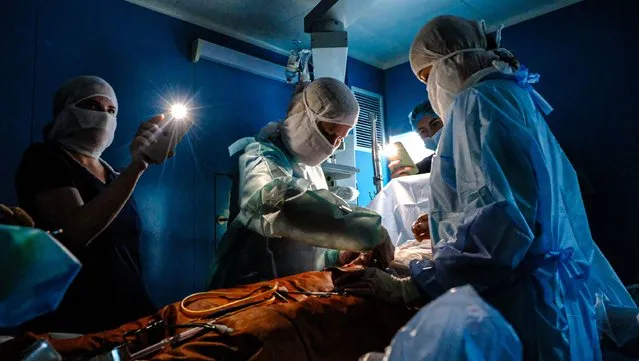 Doctors operate with phone flashlights after power outages due to conflicts within the Russian-Ukrainian war in Kyiv, Ukraine on November 30, 2022. (Photo by Abdullah Unver/Anadolu Agency via Getty Images)